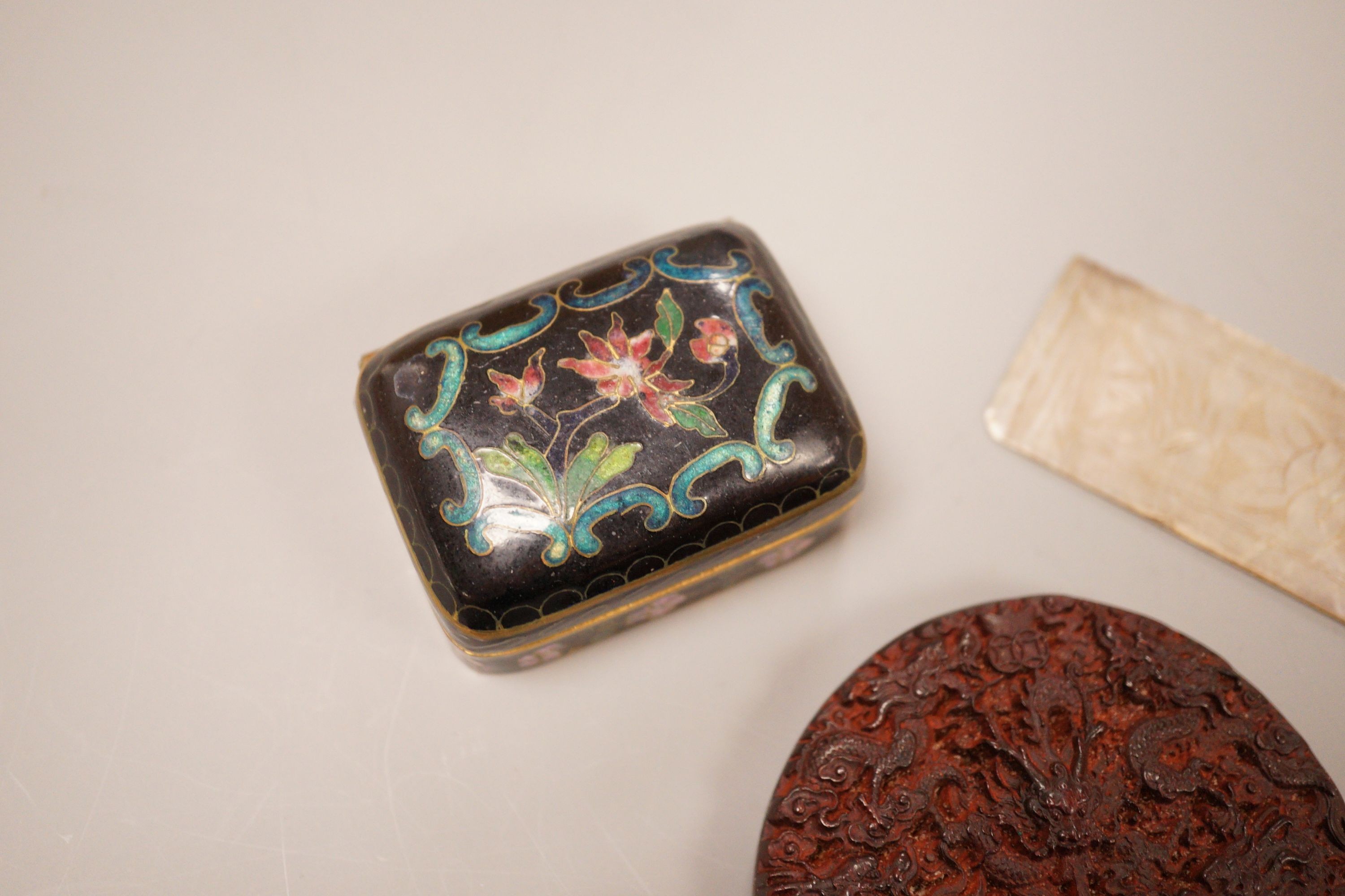 A Chinese cloisonne box, a lacquer carving and a mother of pearl counter